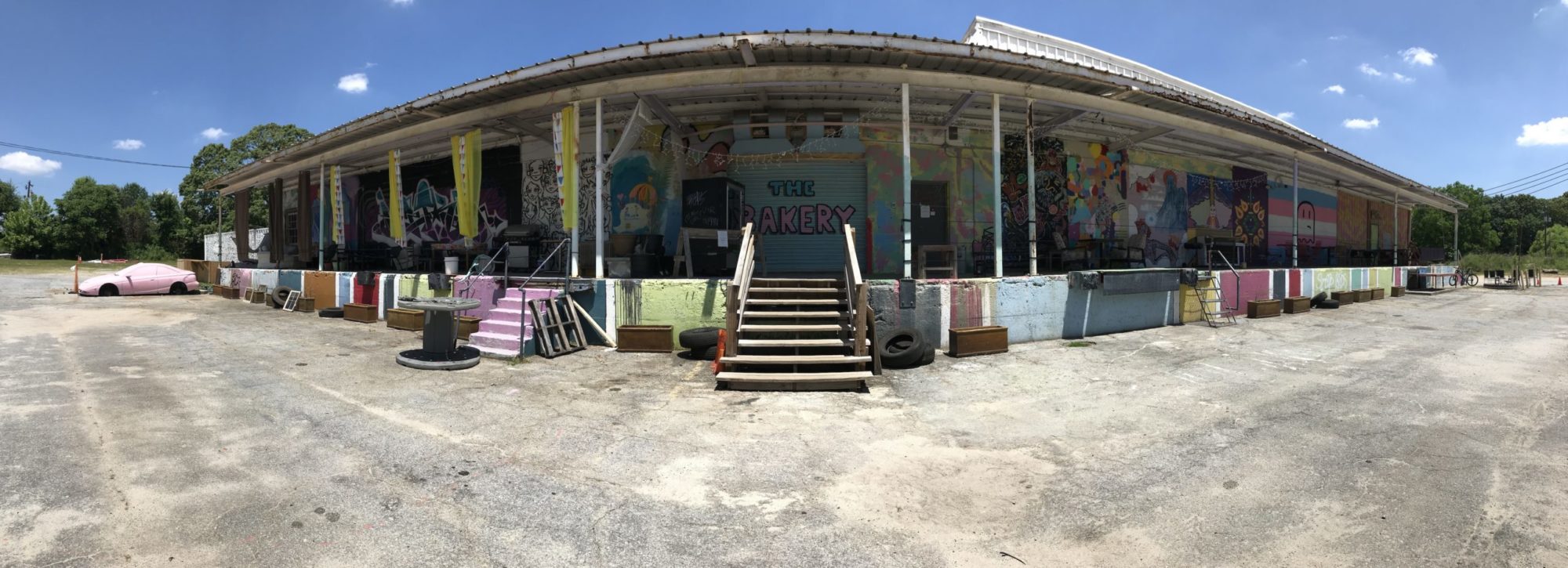 A panorama view of a building covered in colorful graffiti.