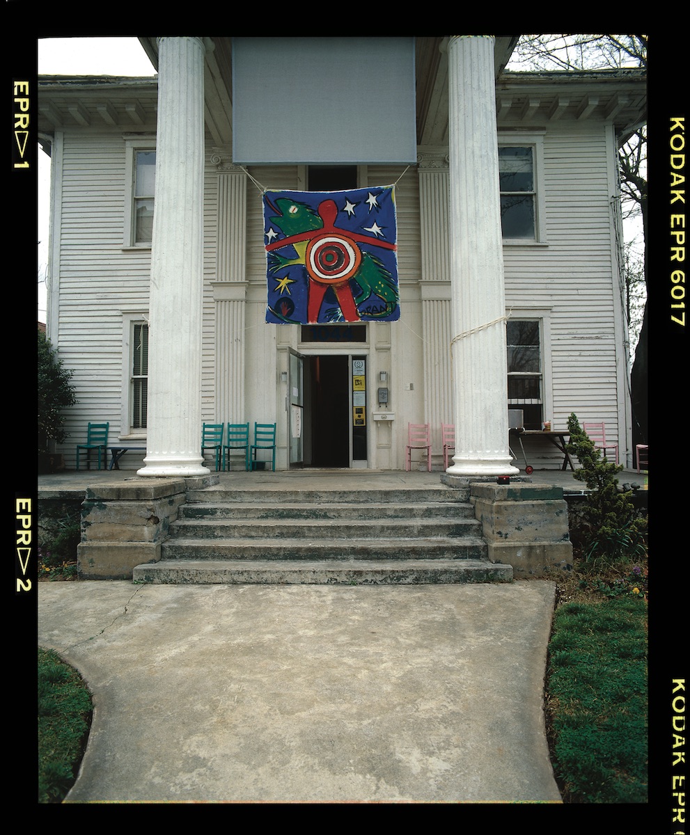 A photograph of the outside of Blue Rat Gallery. A colorful painting hangs in the entryway.