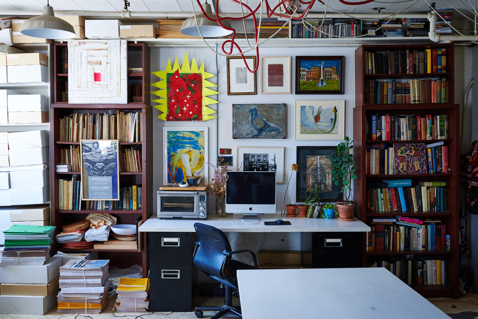 An office desk with bookshelves to its left and right.