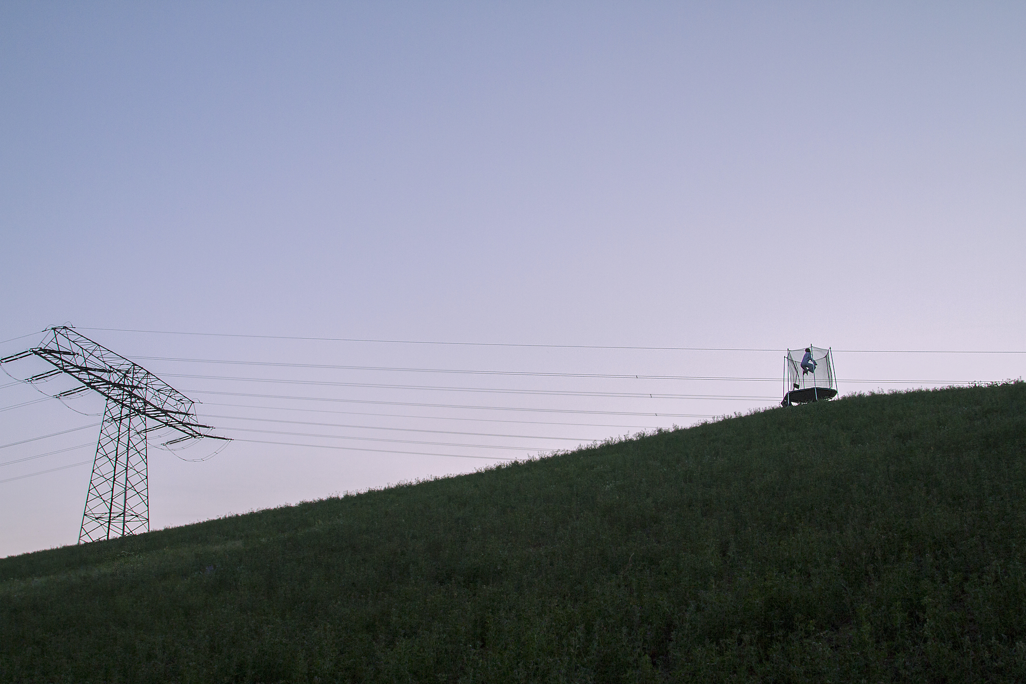 landscape of power lines and a netted trampoline far away