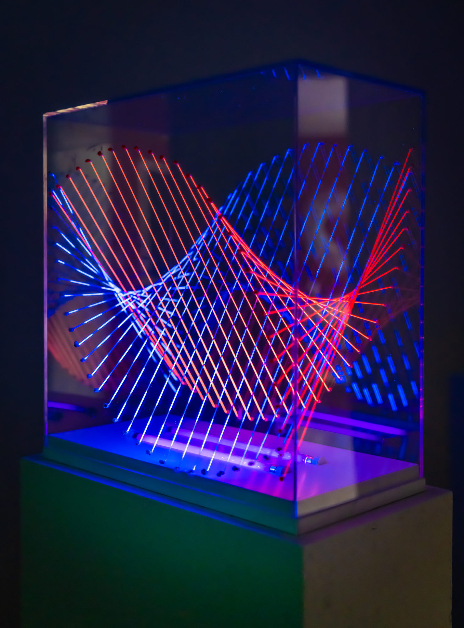 black-lit blue and red string enclosed in glass case