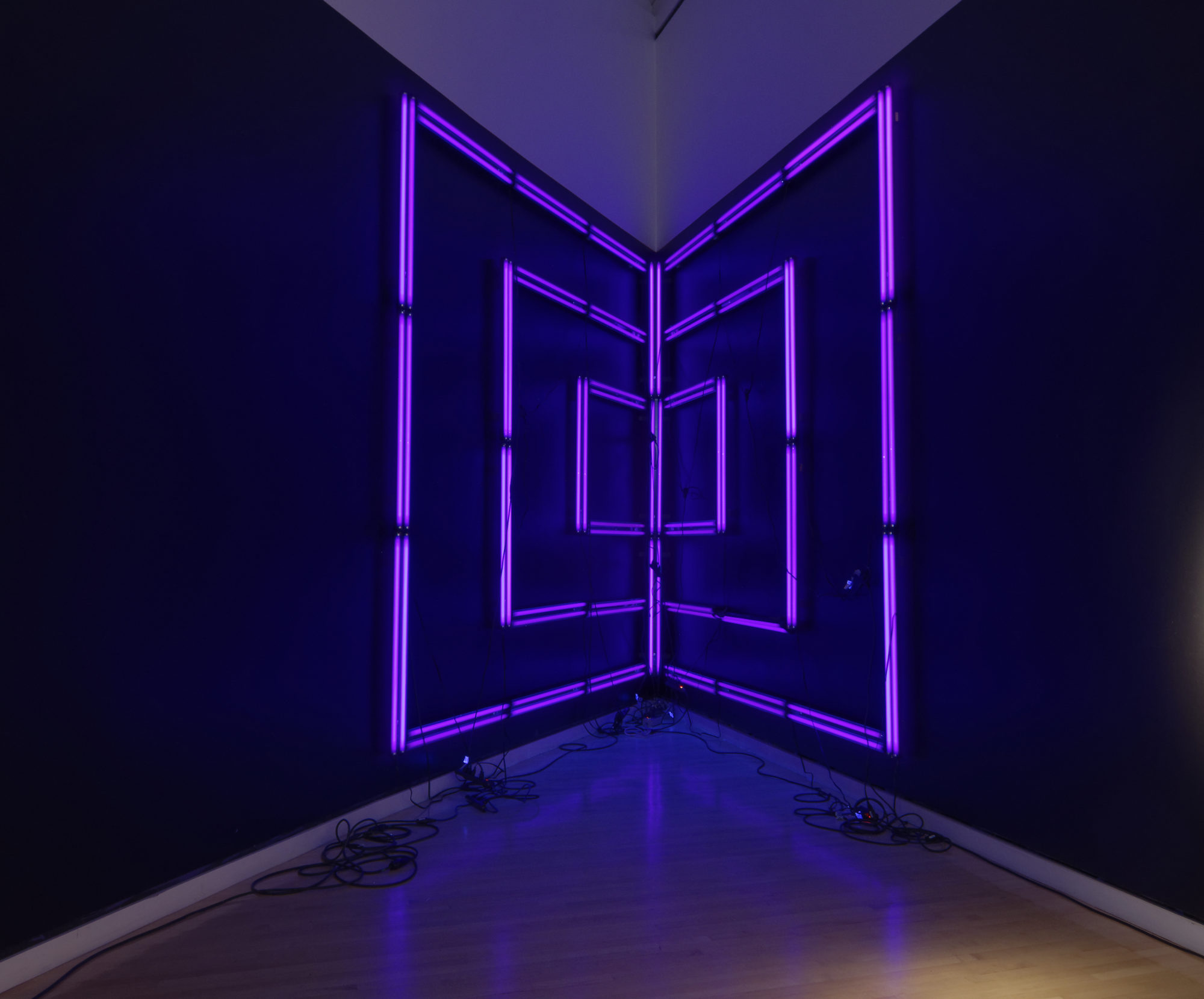 Purple LED strip lights set in a square geometric display in the corner of the wall