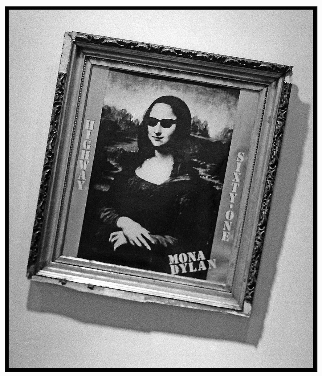 A black and white photograph of a framed and tilted version of Mona Lisa with sunglasses and the text 