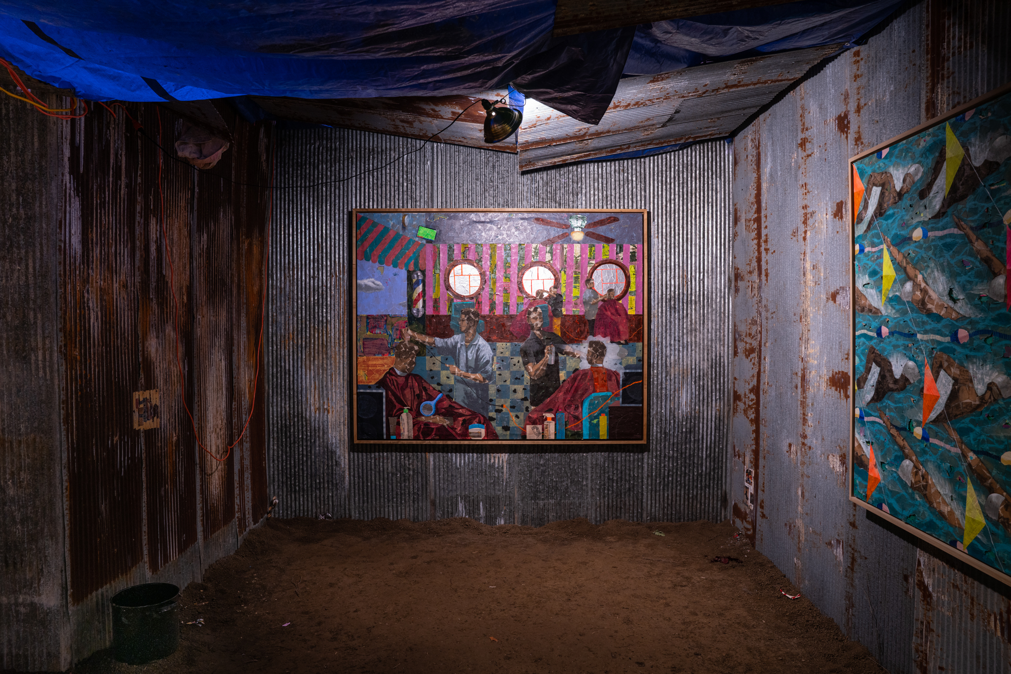 A photo of Derek Fordjour's exhibit SHELTER, displaying sheets of corrugated metal that surround the displayed paintings.