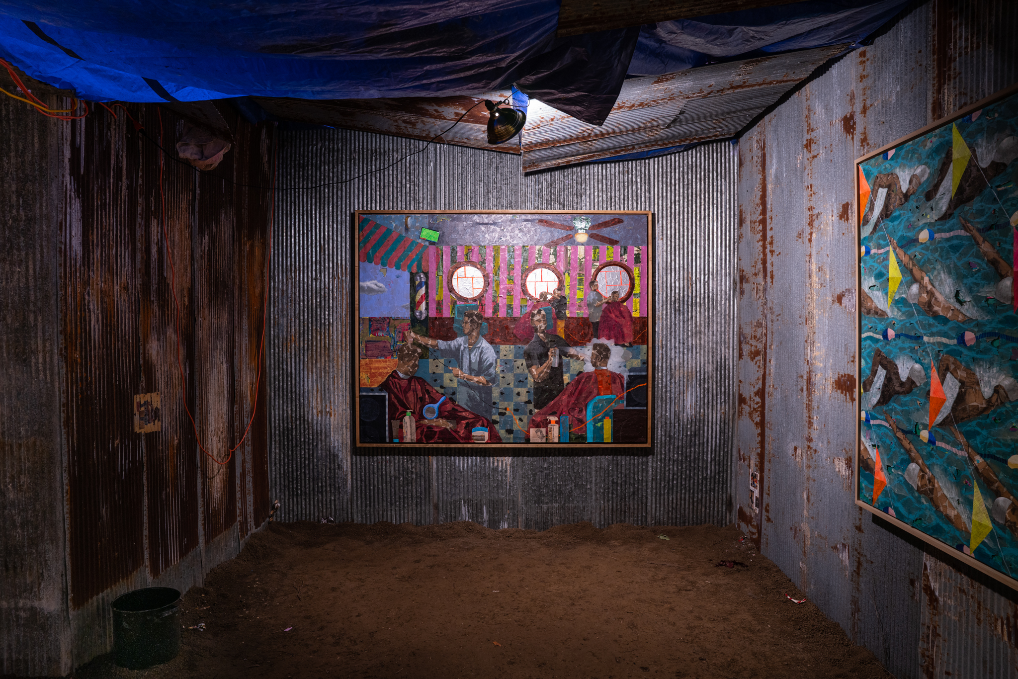 A photo of Derek Fordjour's exhibit SHELTER, displaying sheets of corrugated metal that surround the displayed paintings.
