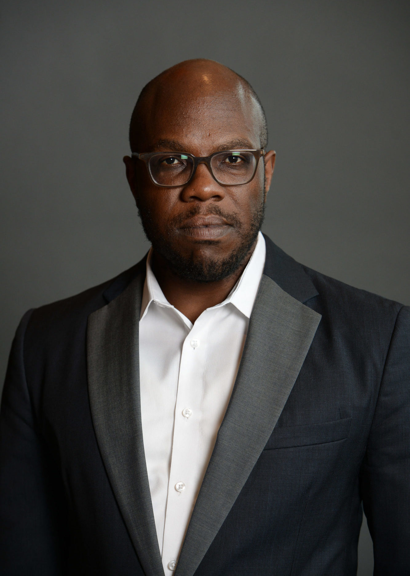 headshot of Dr. Huey Copeland dressed in a dress shirt and blazer