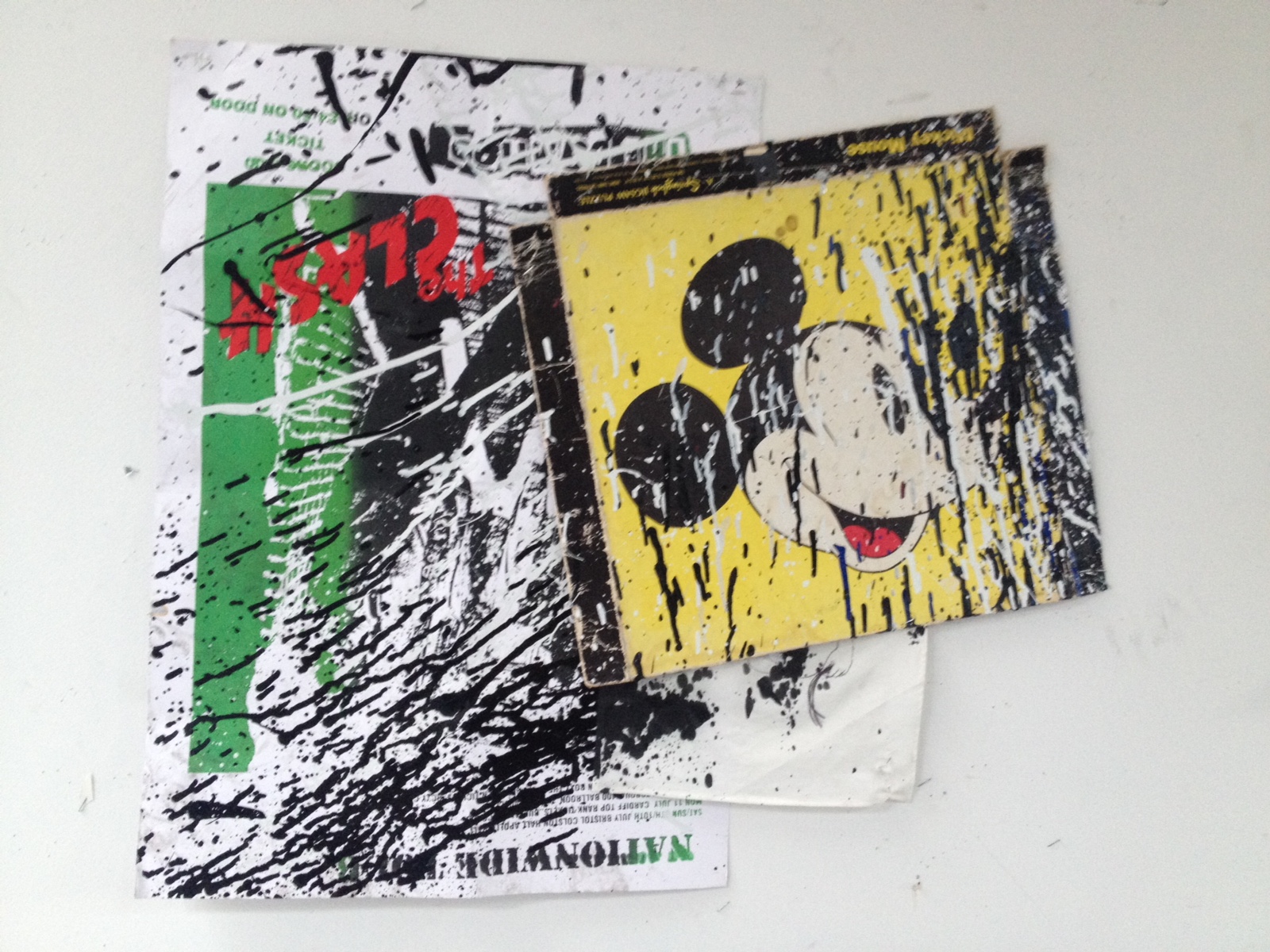 Photograph of two images pasted together, one of a mouse cartoon and the other unintelligible under the black and white paint splatter.