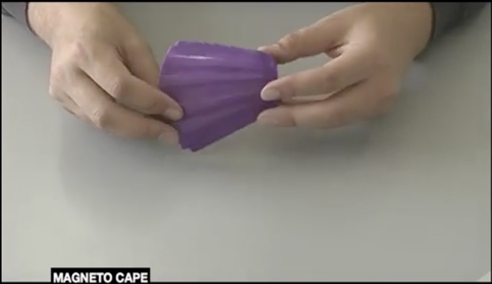Hands hold a purple object with the caption 