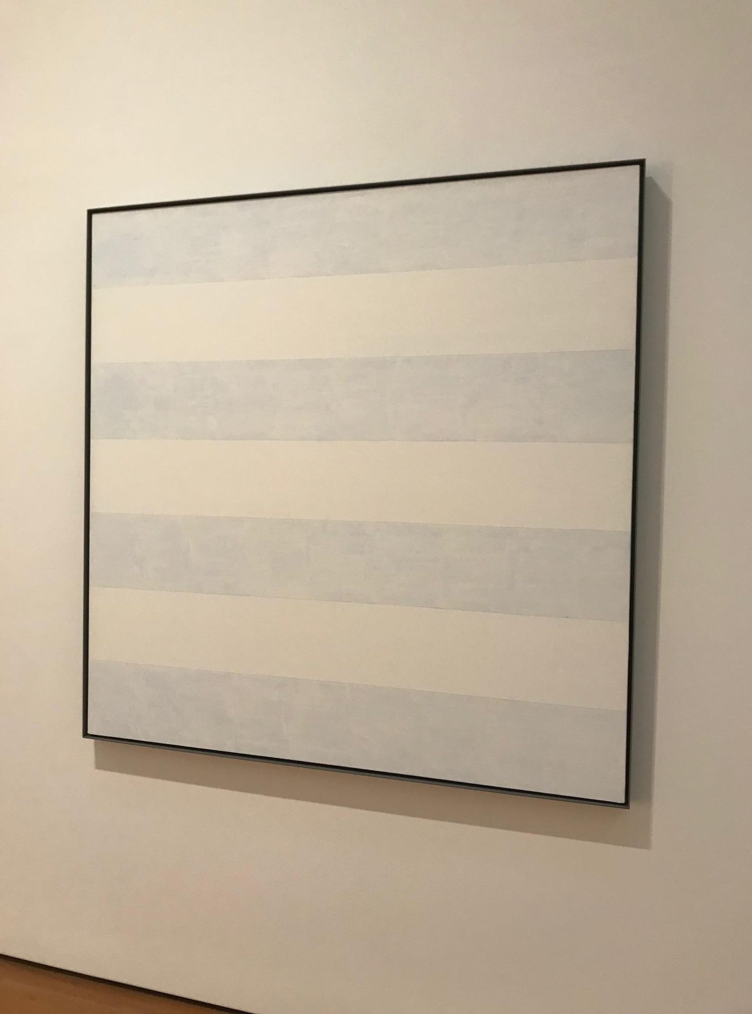 Installation view of Agnes Martin's work at the High Museum, blue and white horizontal stripes.