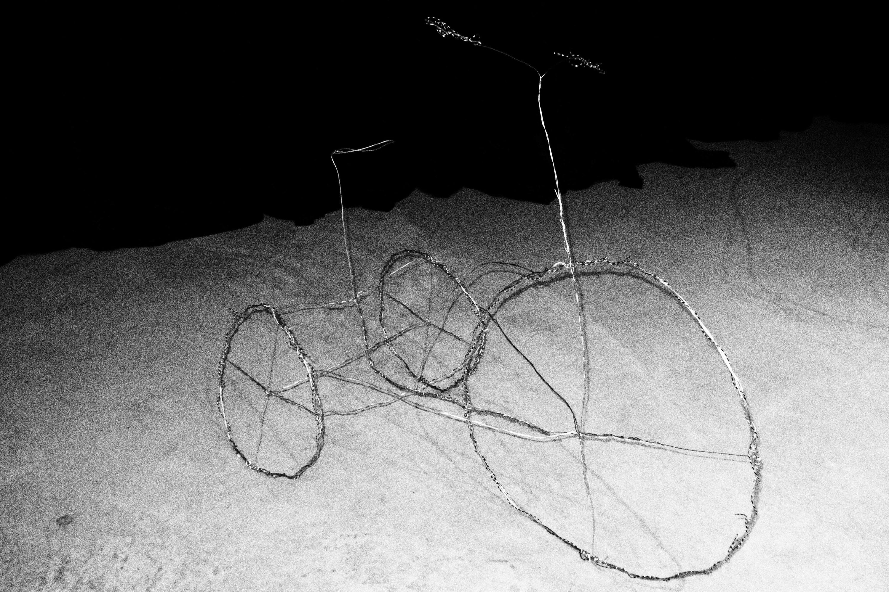 black and white image of a tricycle made out of wire that is wrapped around itself