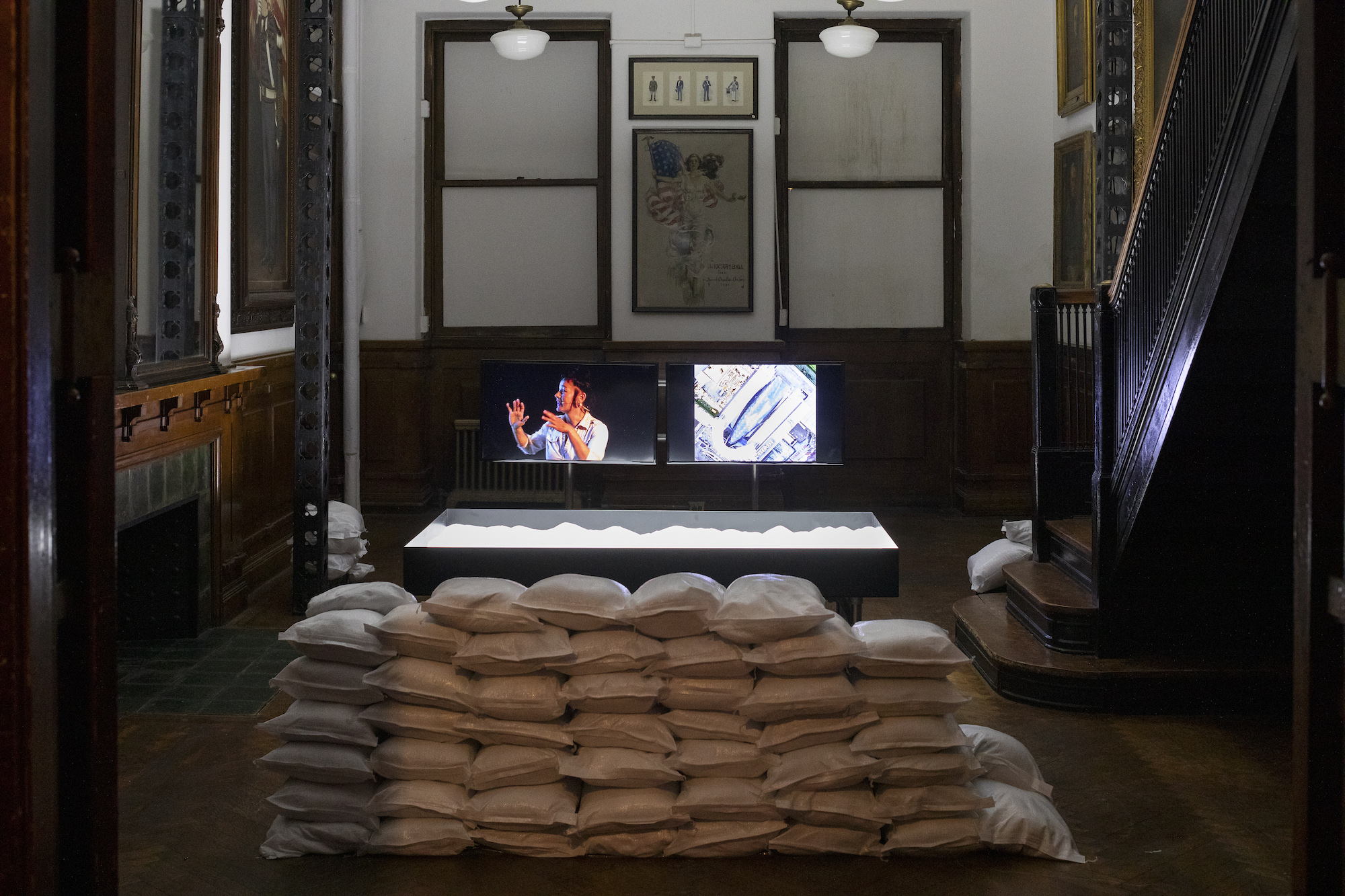 An image of a screen with sandbags stacked in front of it.