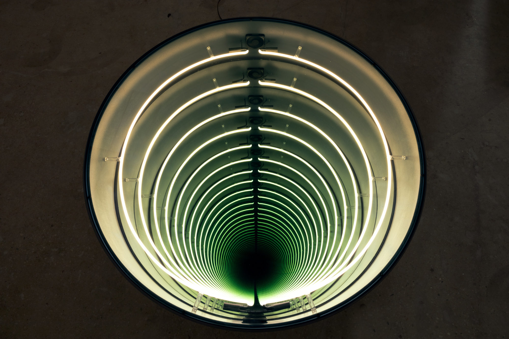 Round glass, light, and mirror sculpture.