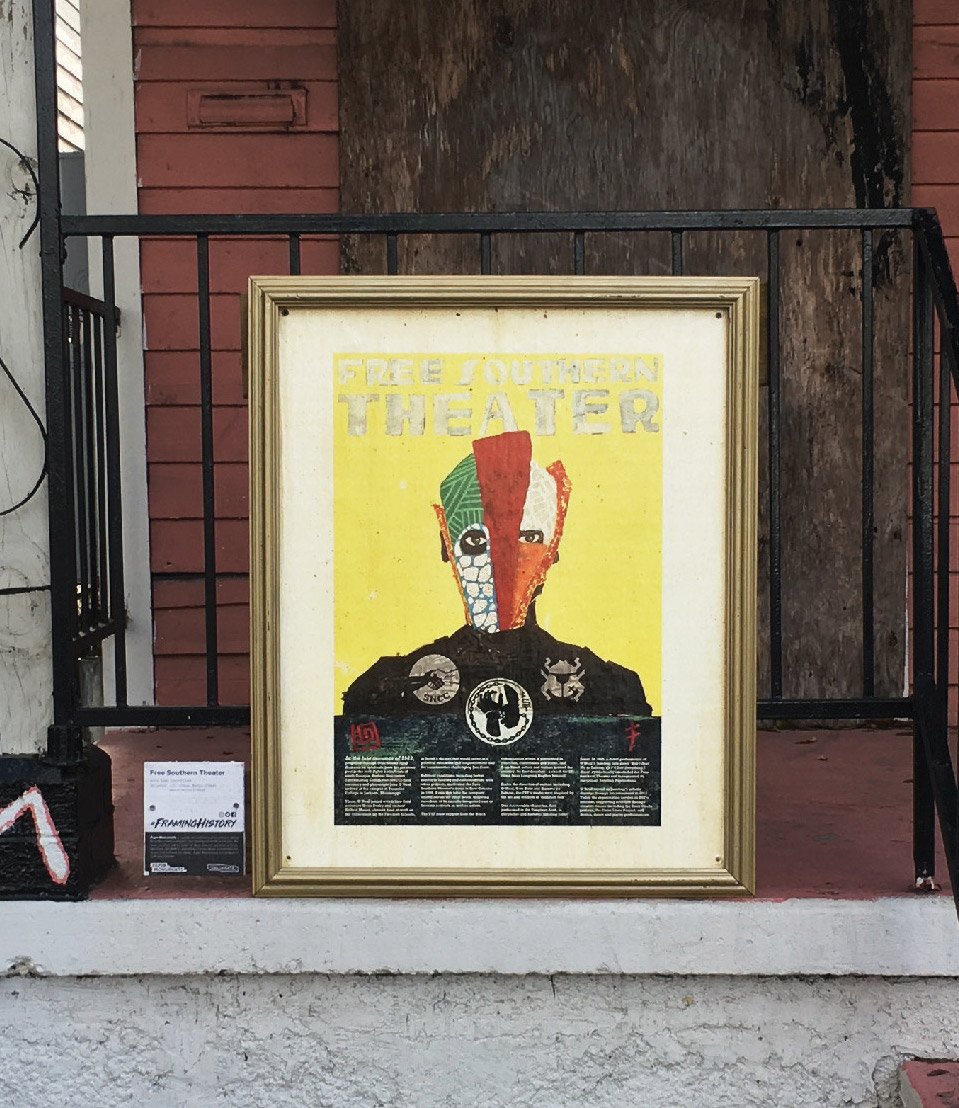 A photo of a framed poster propped up on a porch.