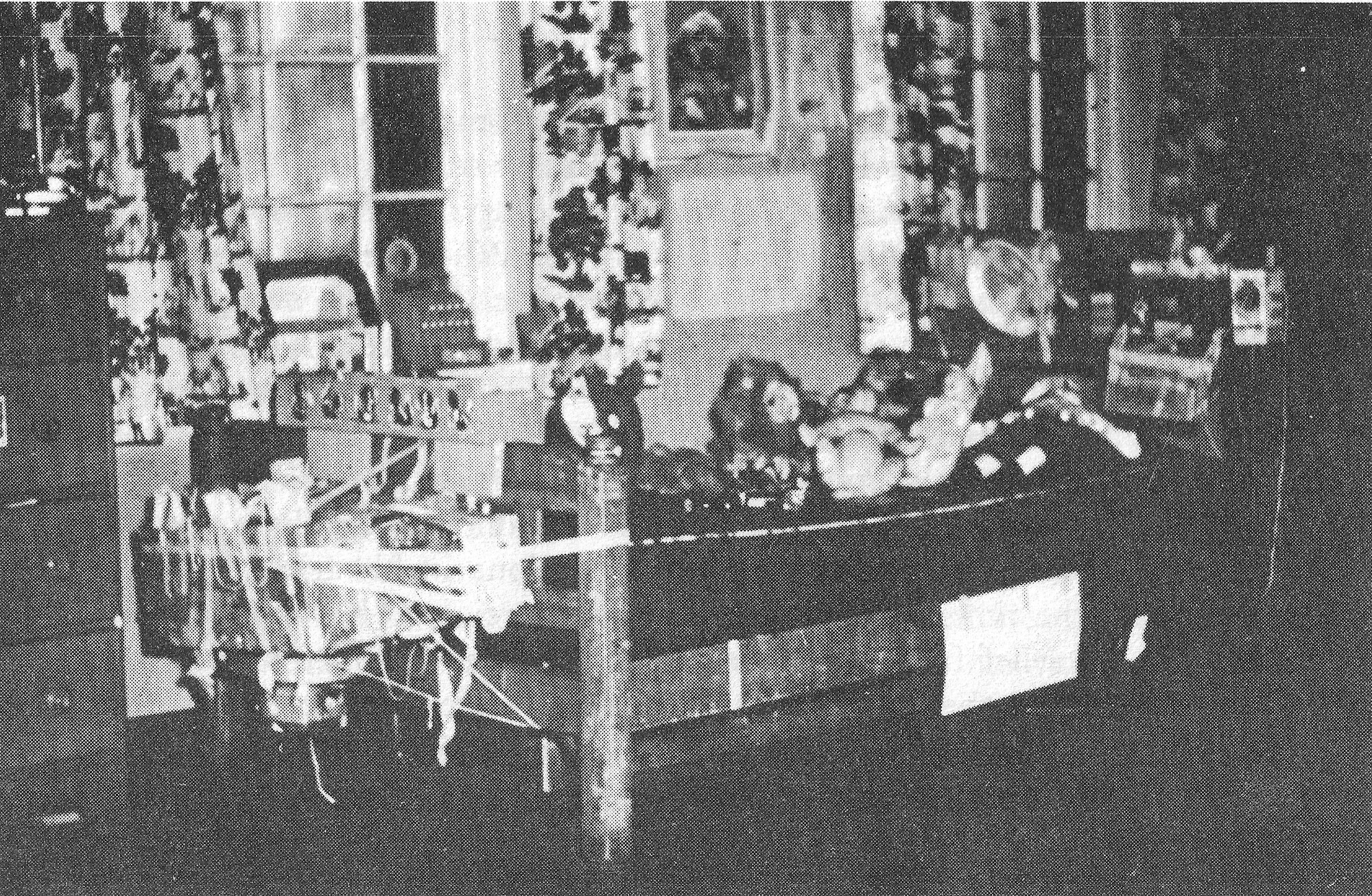 black and white photo of a bedroom full of various objects