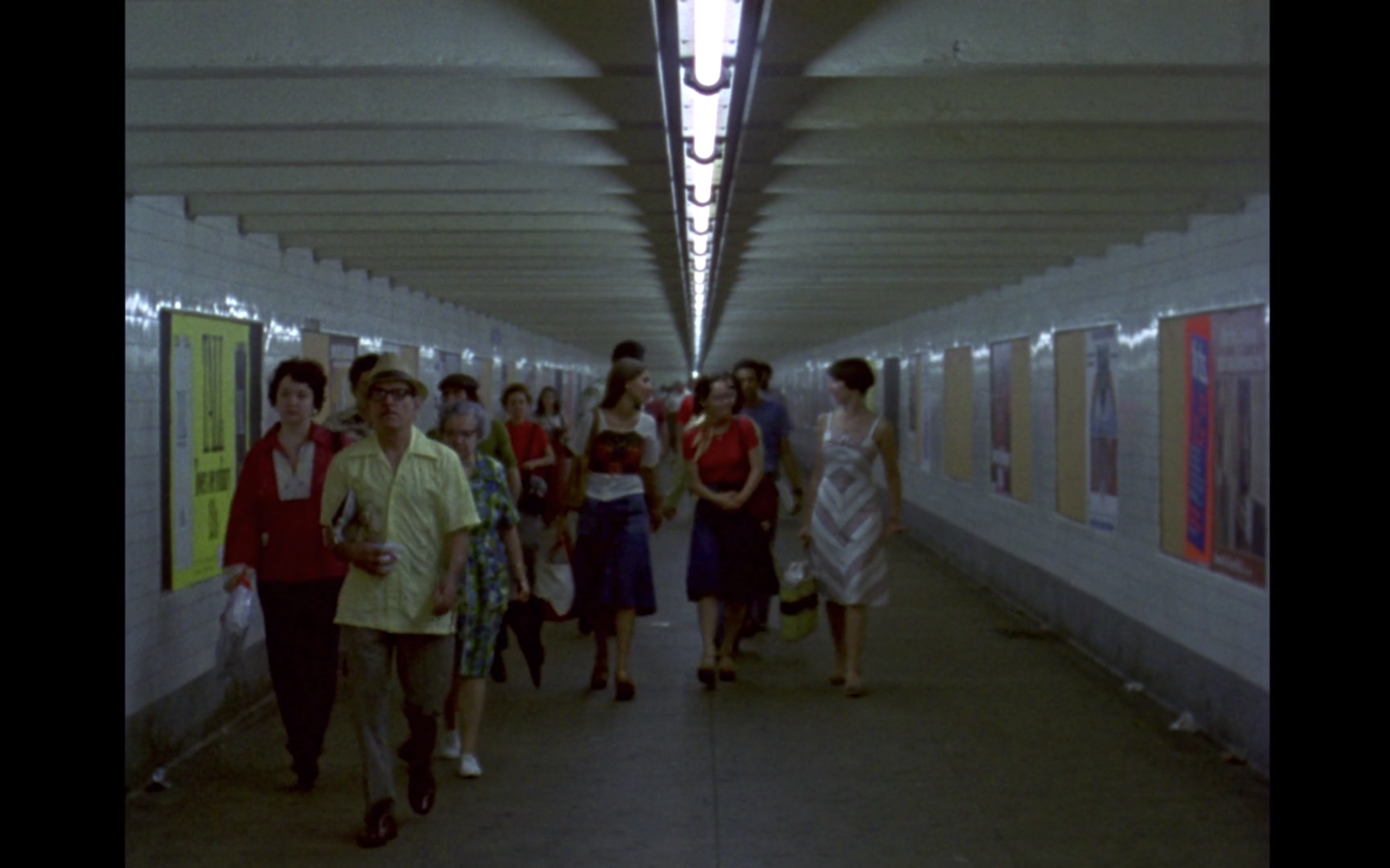 Screenshot from film News From Home displaying people walking through a tunnel