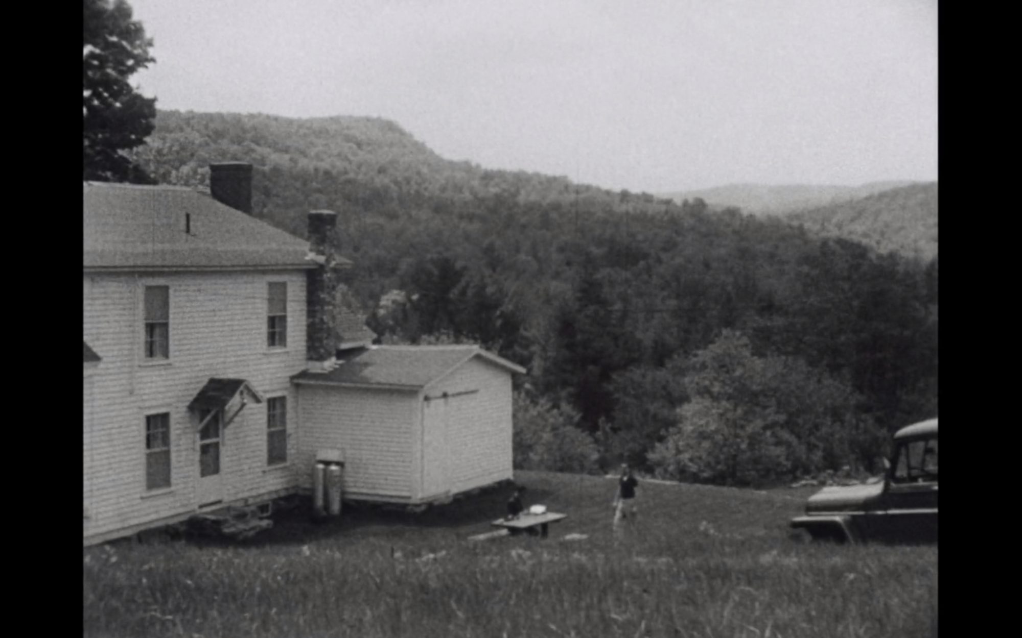 Screenshot from film Lost,Lost,Lost displaying the backside of a house ,man , and tractor