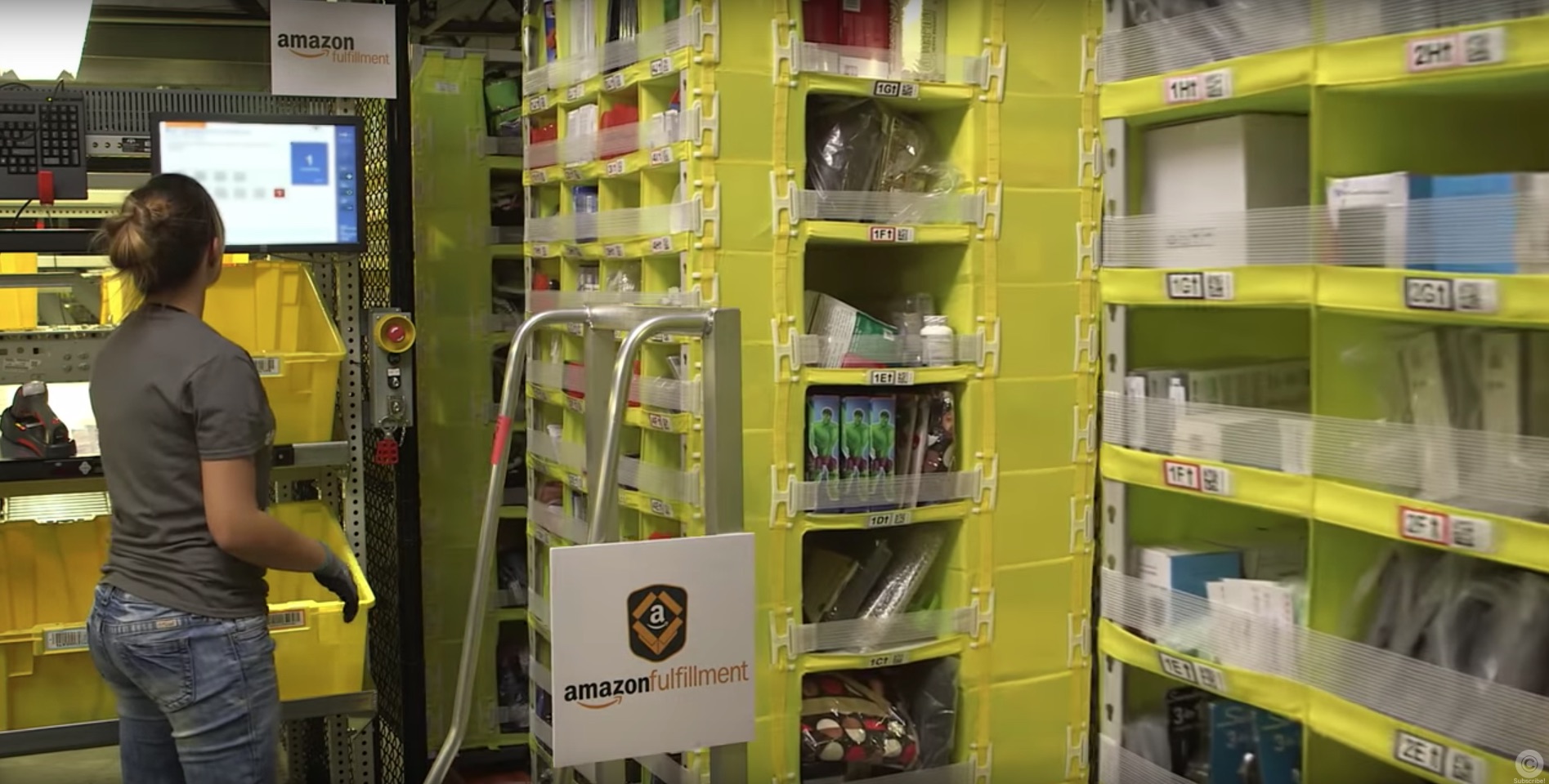 Woman in an amazon warehouse looking at a computer