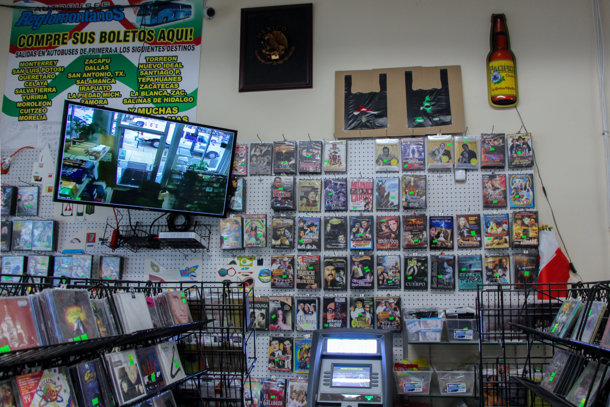 DVD section of a convenience store with TV mounted overhead
