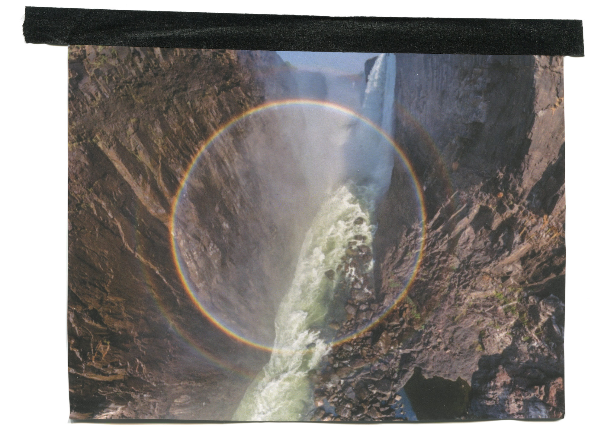 A photo of Victoria Falls with a circular rainbow superimposed over the top.