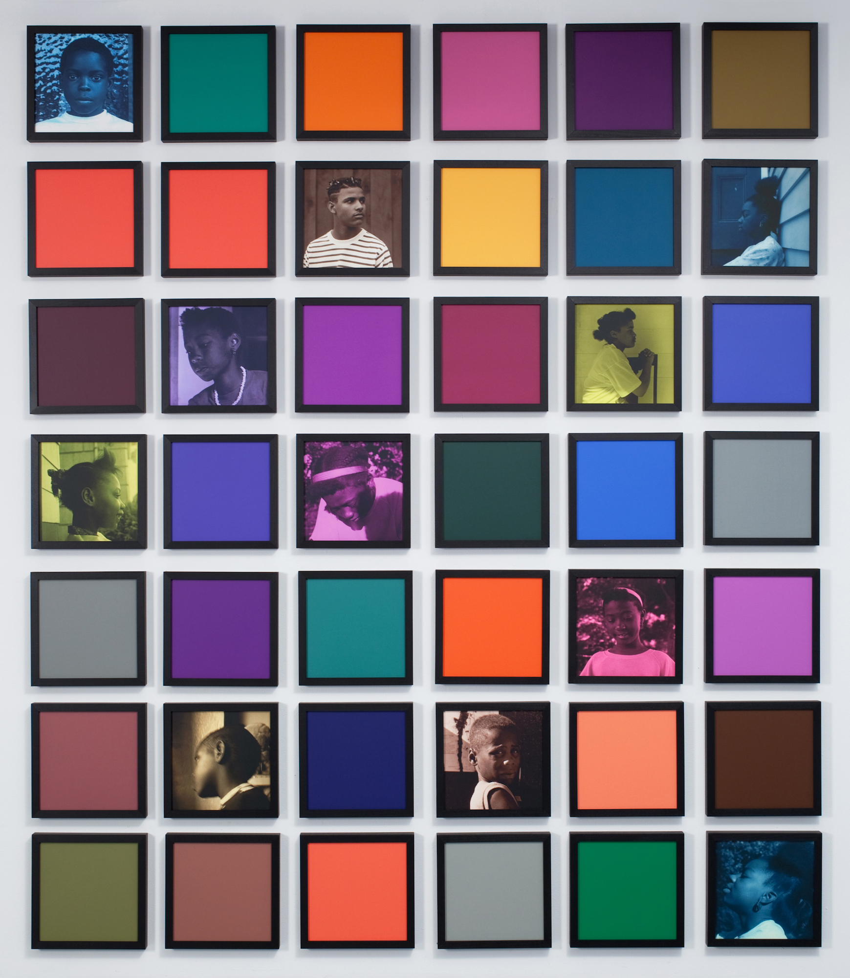 42 multi-colored, black framed square panels arranged in a grid. Eleven squares with a portrait.