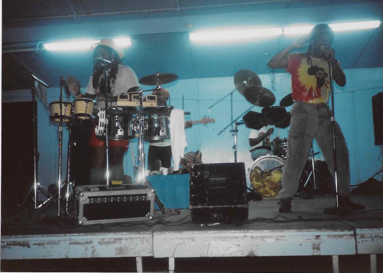An image of a band performing in a venue against a bright blue wall.