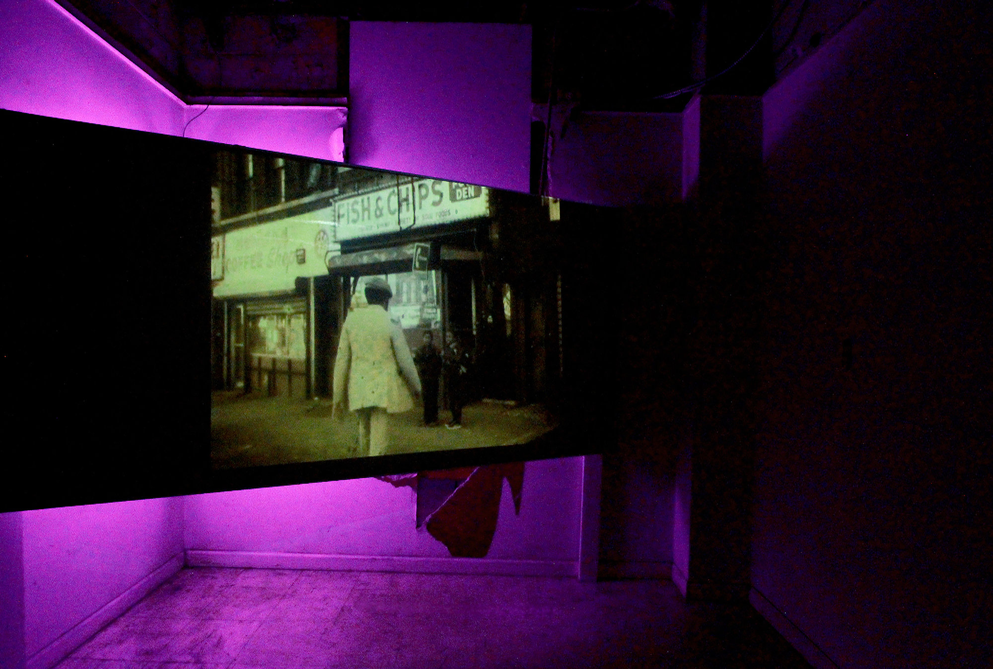 An image of a man entering a store is skewed against a neon purple and black background