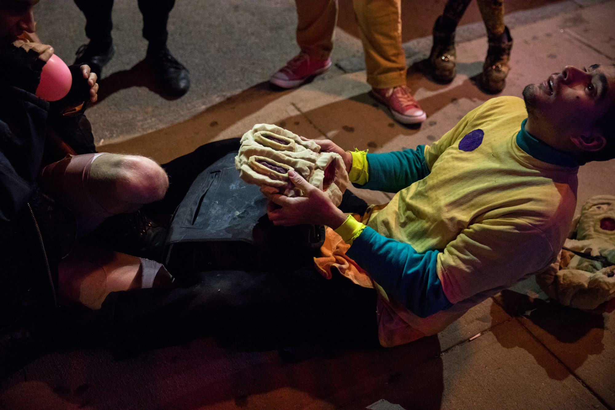 person on their knees holds a mask