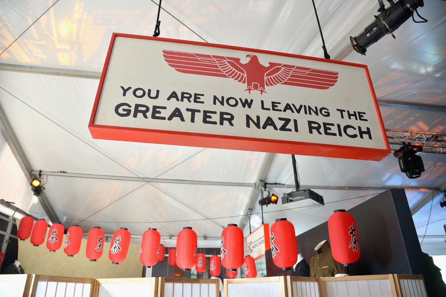 a still from The Man in The High Castle, featuring a piece of Nazi Propaganda surrounded by asian lanterns.