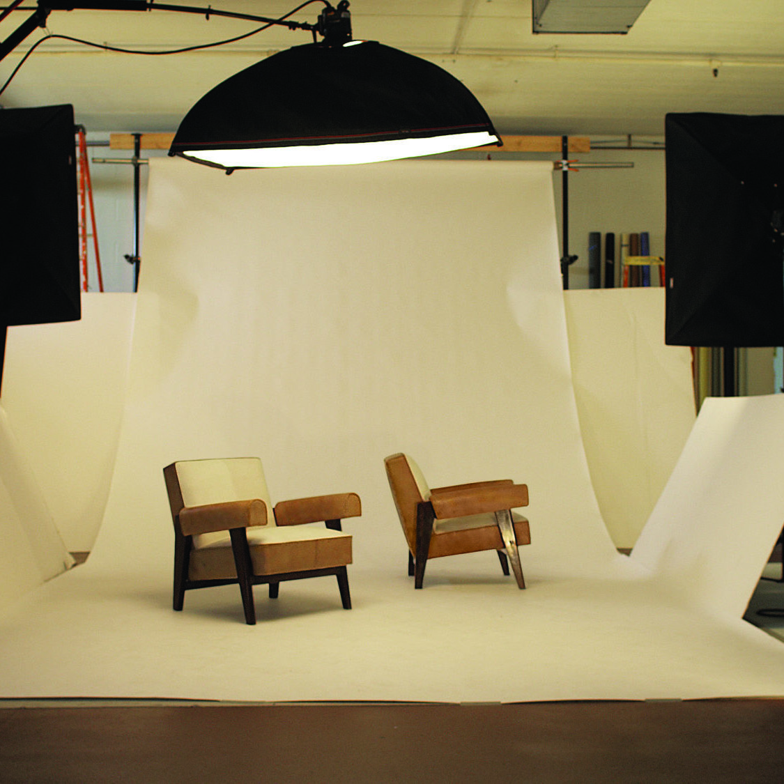 A video still of Amie Siegel's Provenance,2013 featuring a two chairs being photographed in a studio.