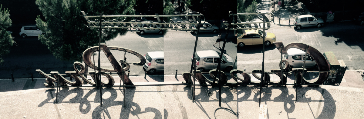 a panoramic view from behind a sign overlooking the street