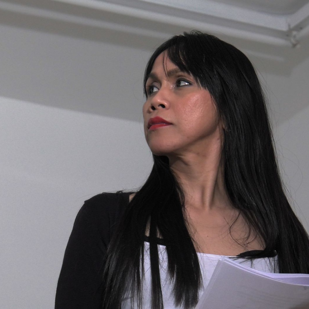 A woman with long black hair looks to the right