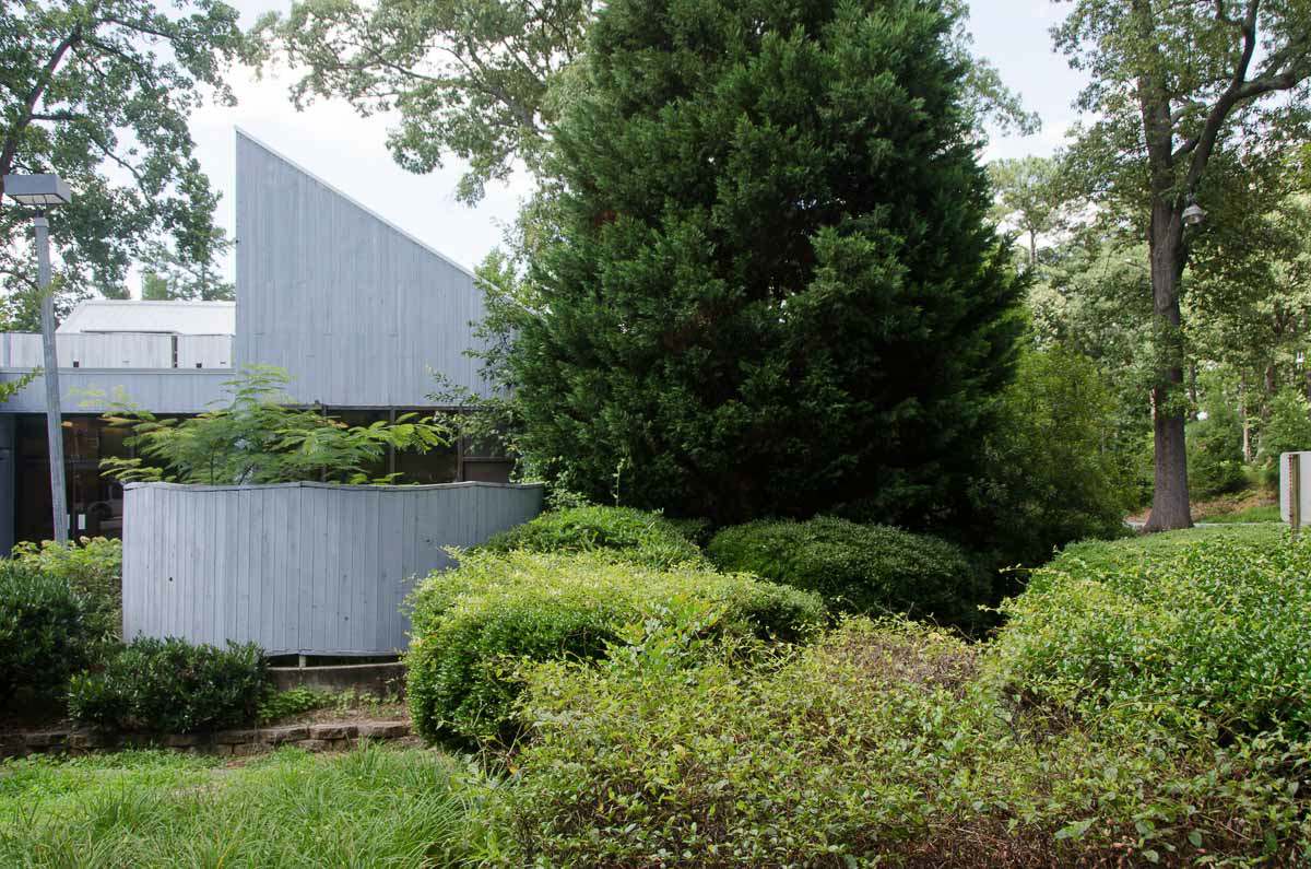 White triangle shaped building surrounded by trees