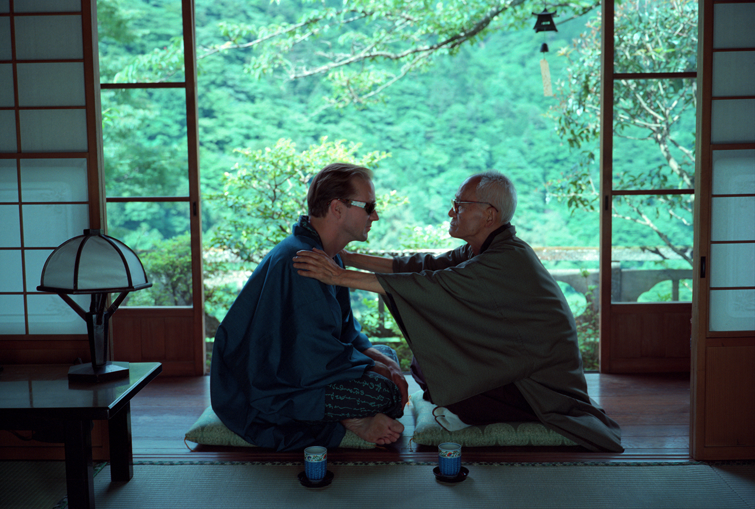 Two men sitting indian-style in a Japanese home