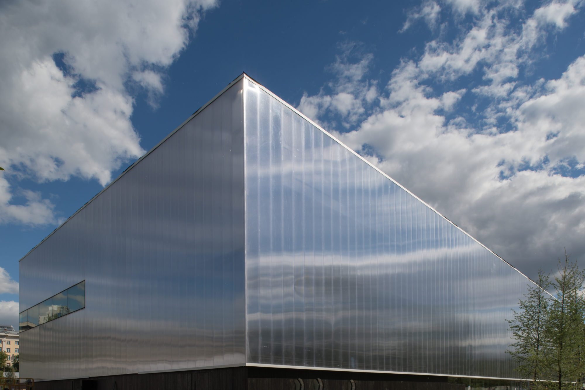 A perspective view of a rectangular building that reflects and distorts the sky