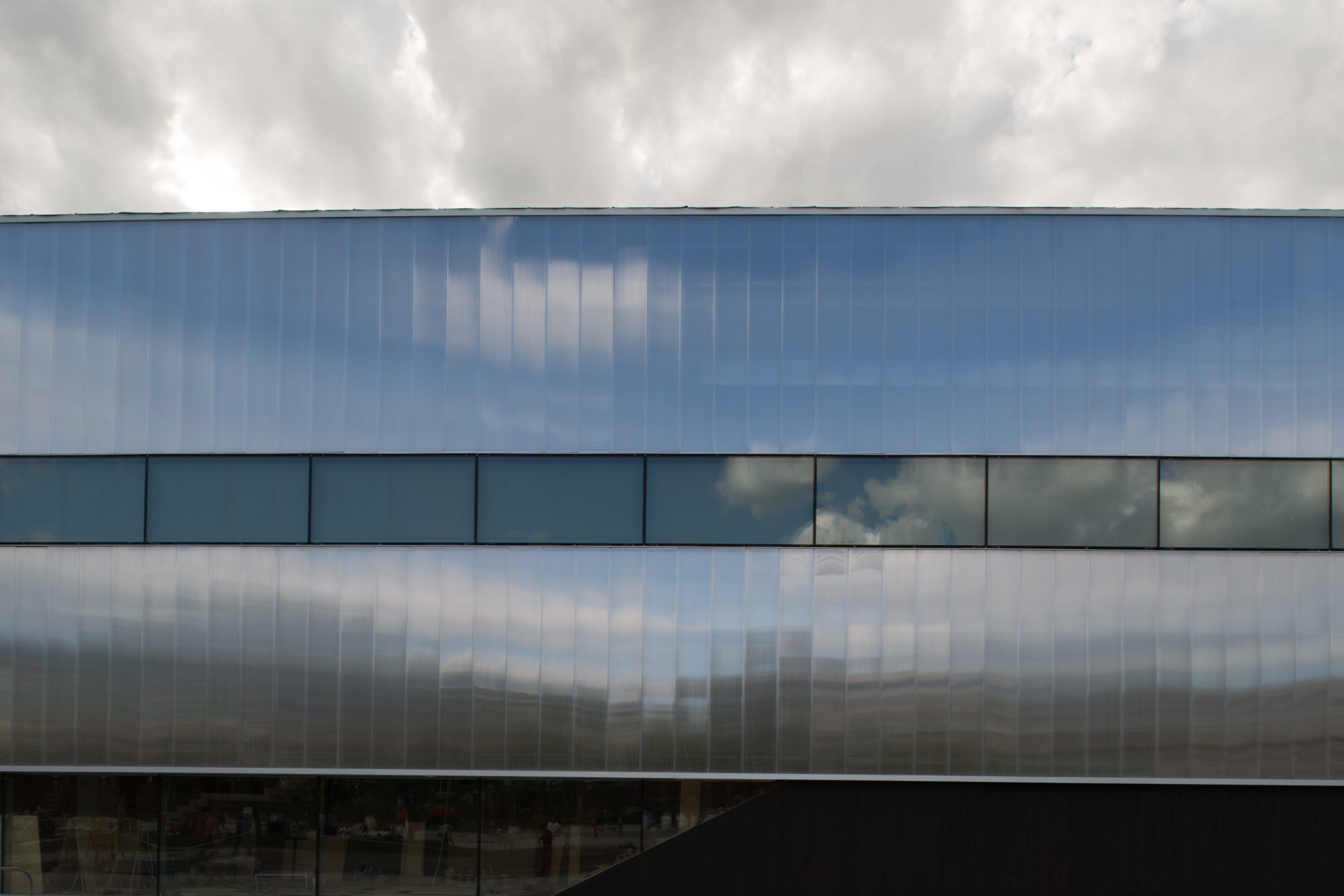 Part of a reflective building with a continuous line of windows