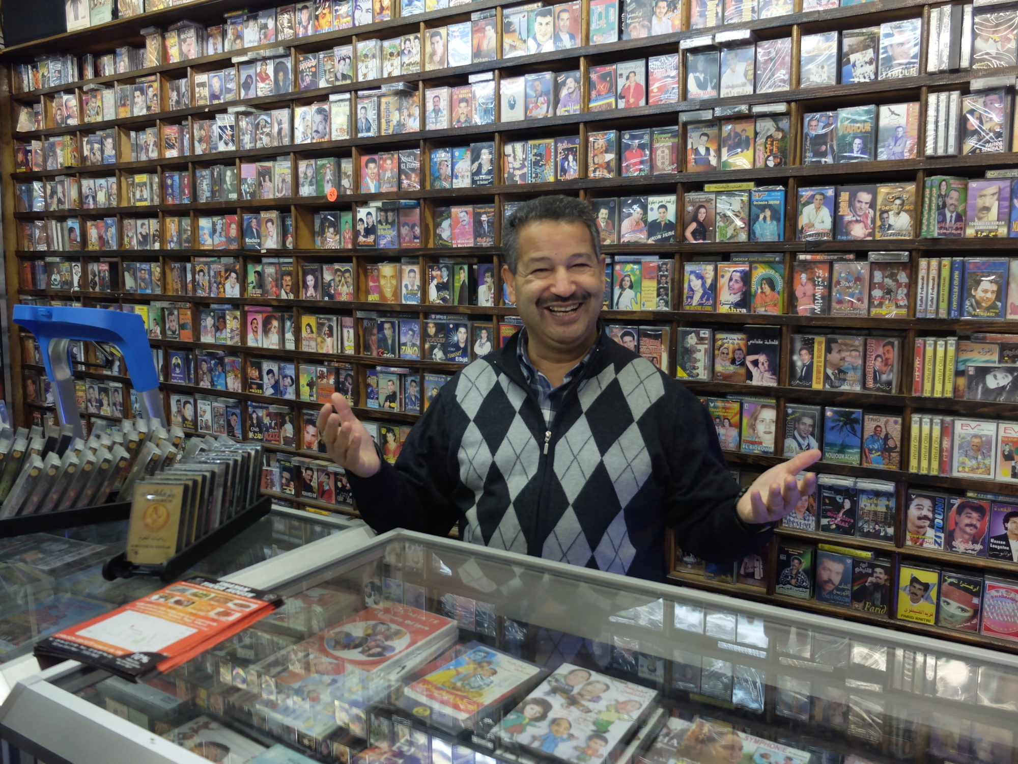 A man behind the counter in a cassette shop