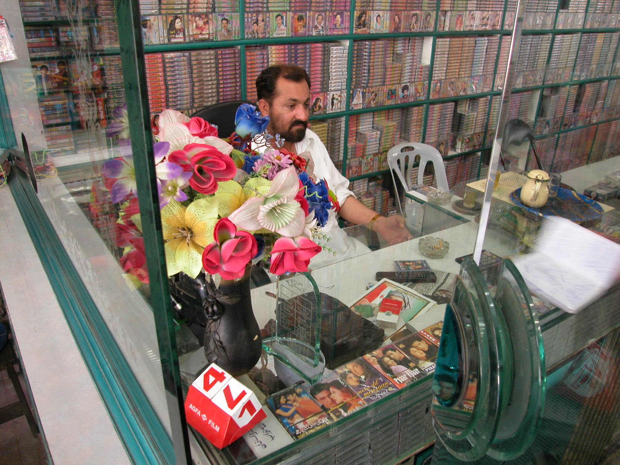 A man behind the counter in a cassette shop