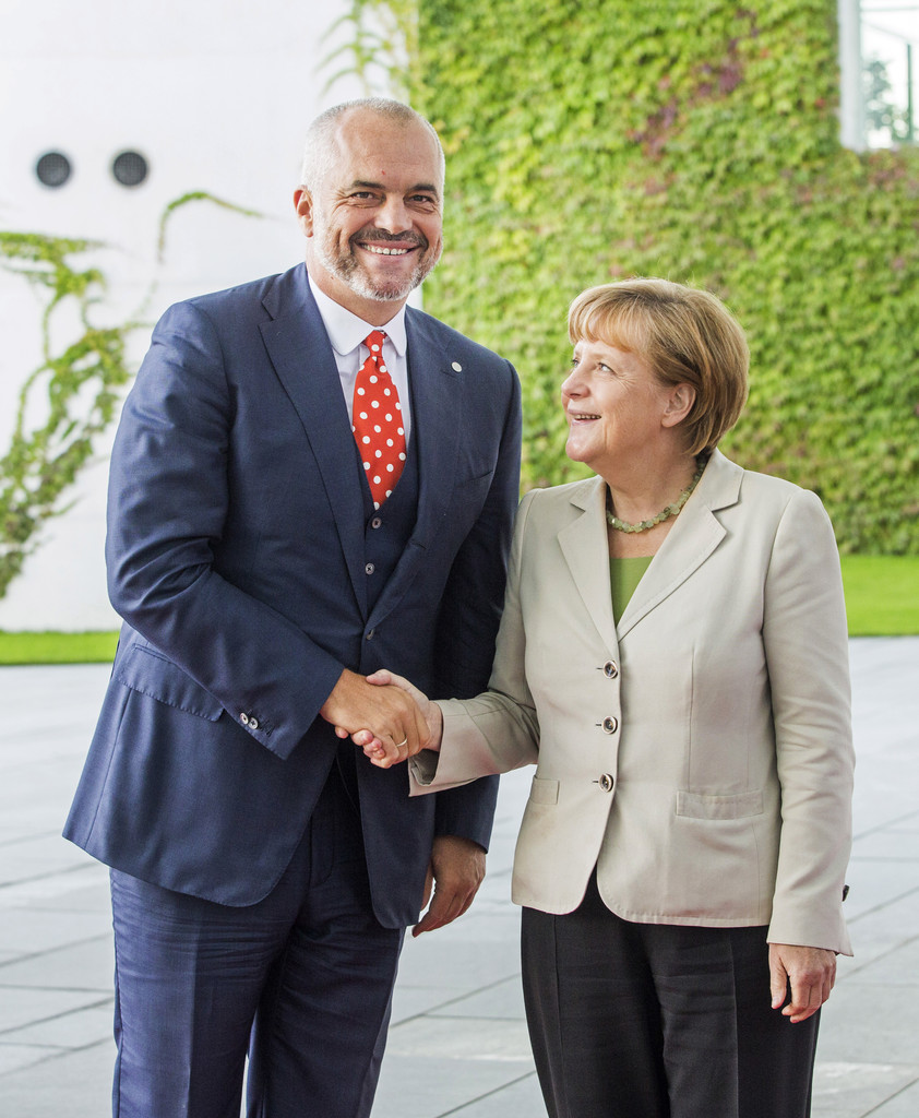 A man and woman smile and shake hands