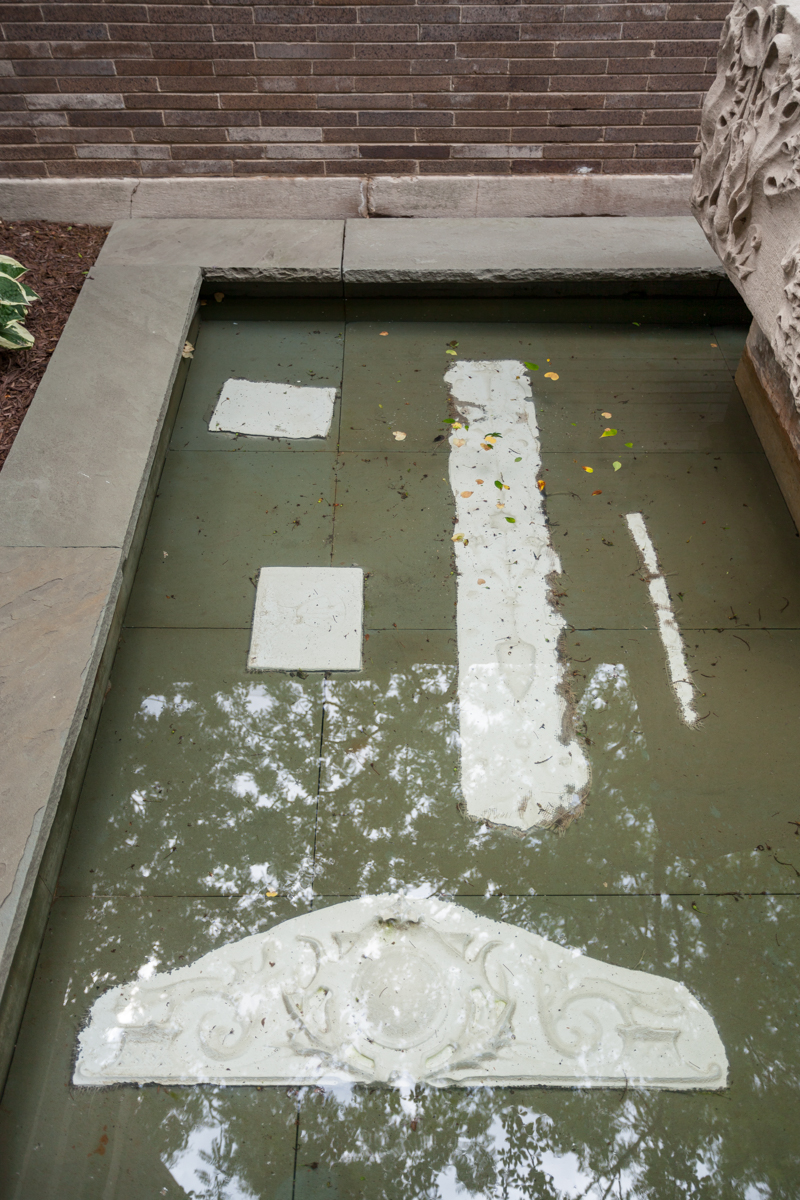 A closeup image of a water fountain containing pieces from Michael Rakowitz.