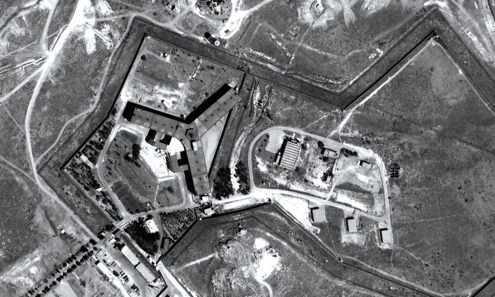 An overhead black and white satellite still of Saydnaya Prison