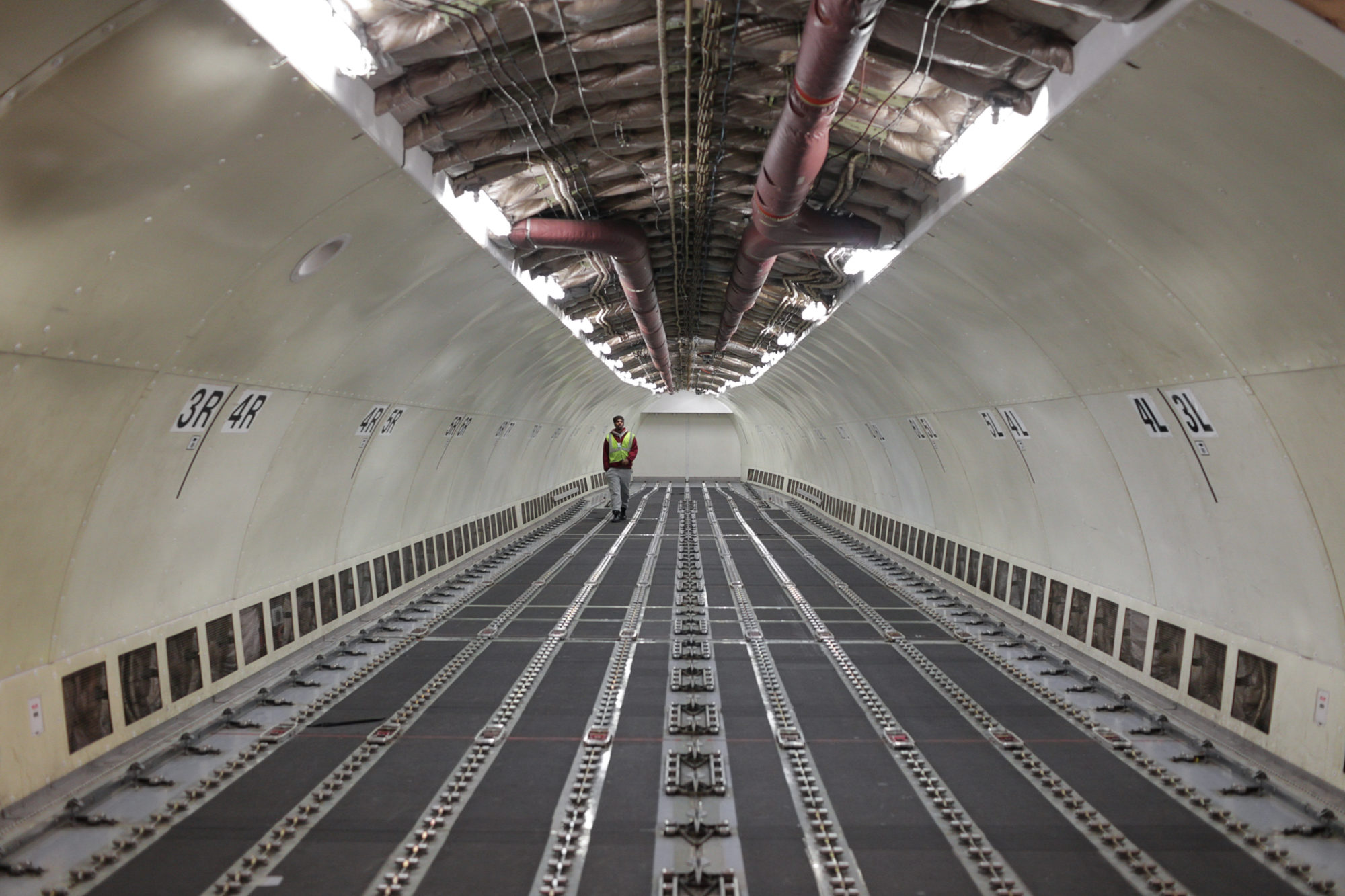 A lone employee, inspecting the bare inside o a UPS airplane.