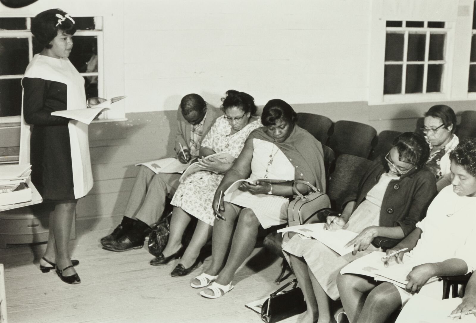 A woman reading to a group as they follow along