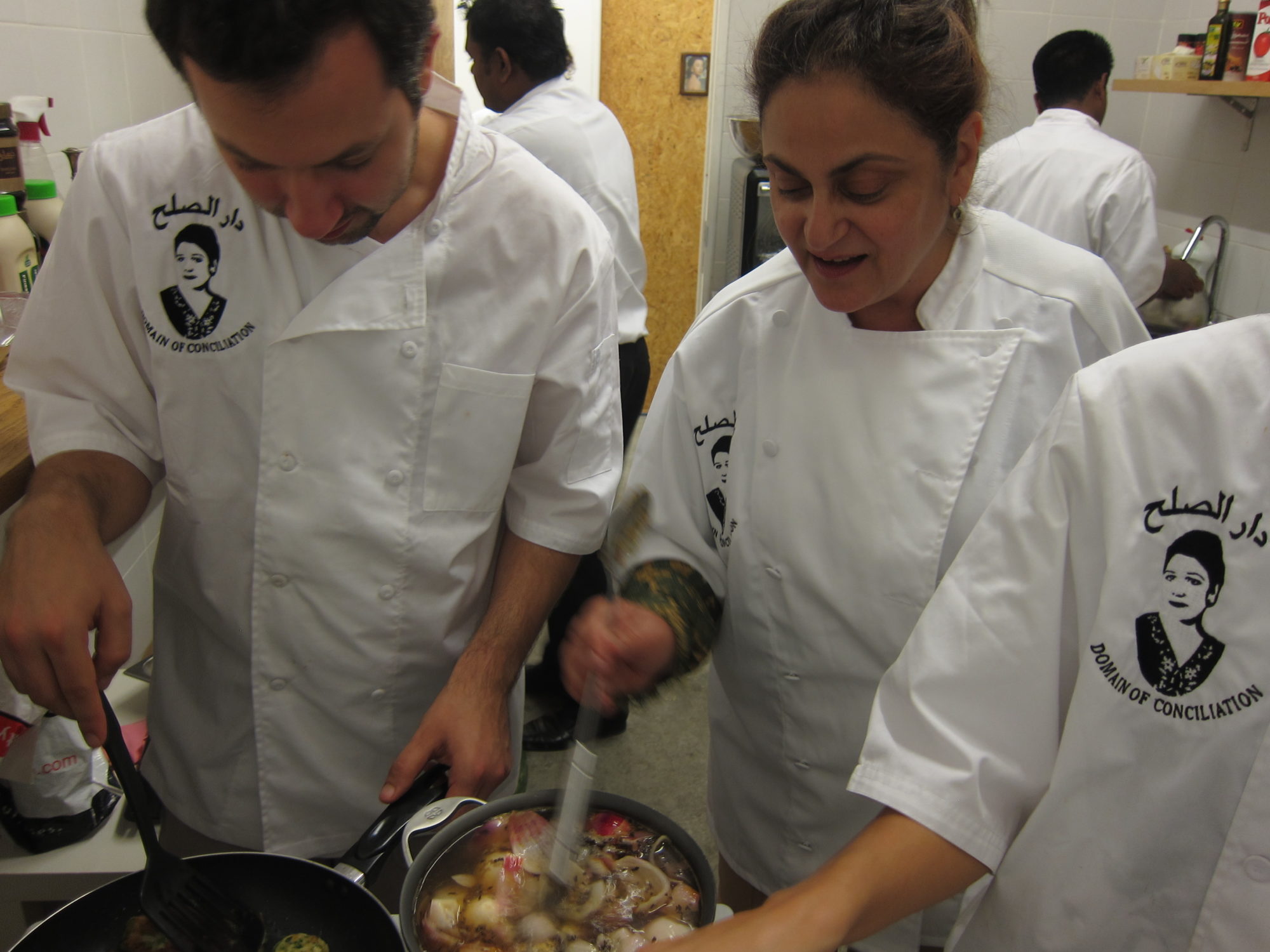 An image of two chefs stirring food.