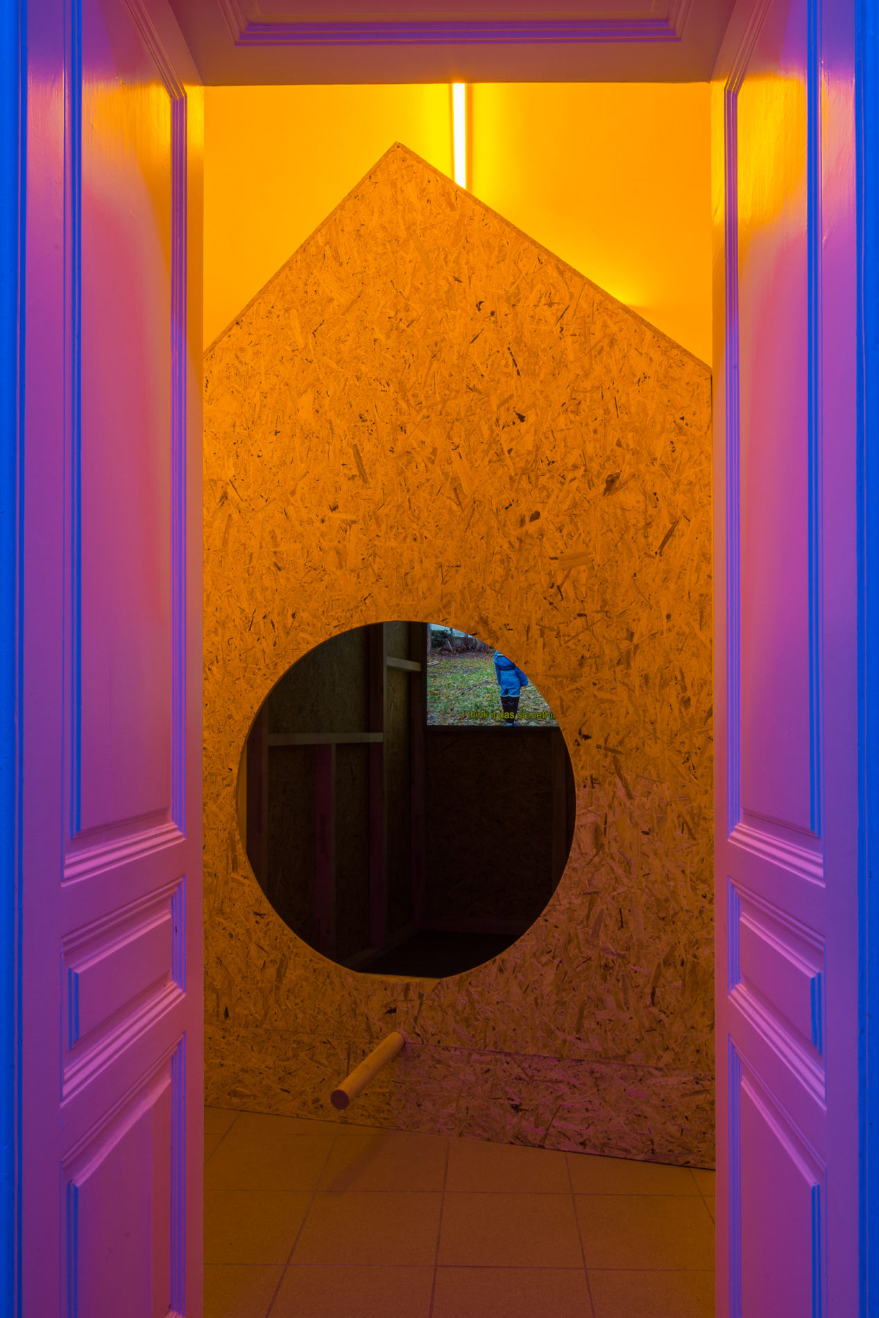 orange triangular structure within purple paneled room with orange backlights