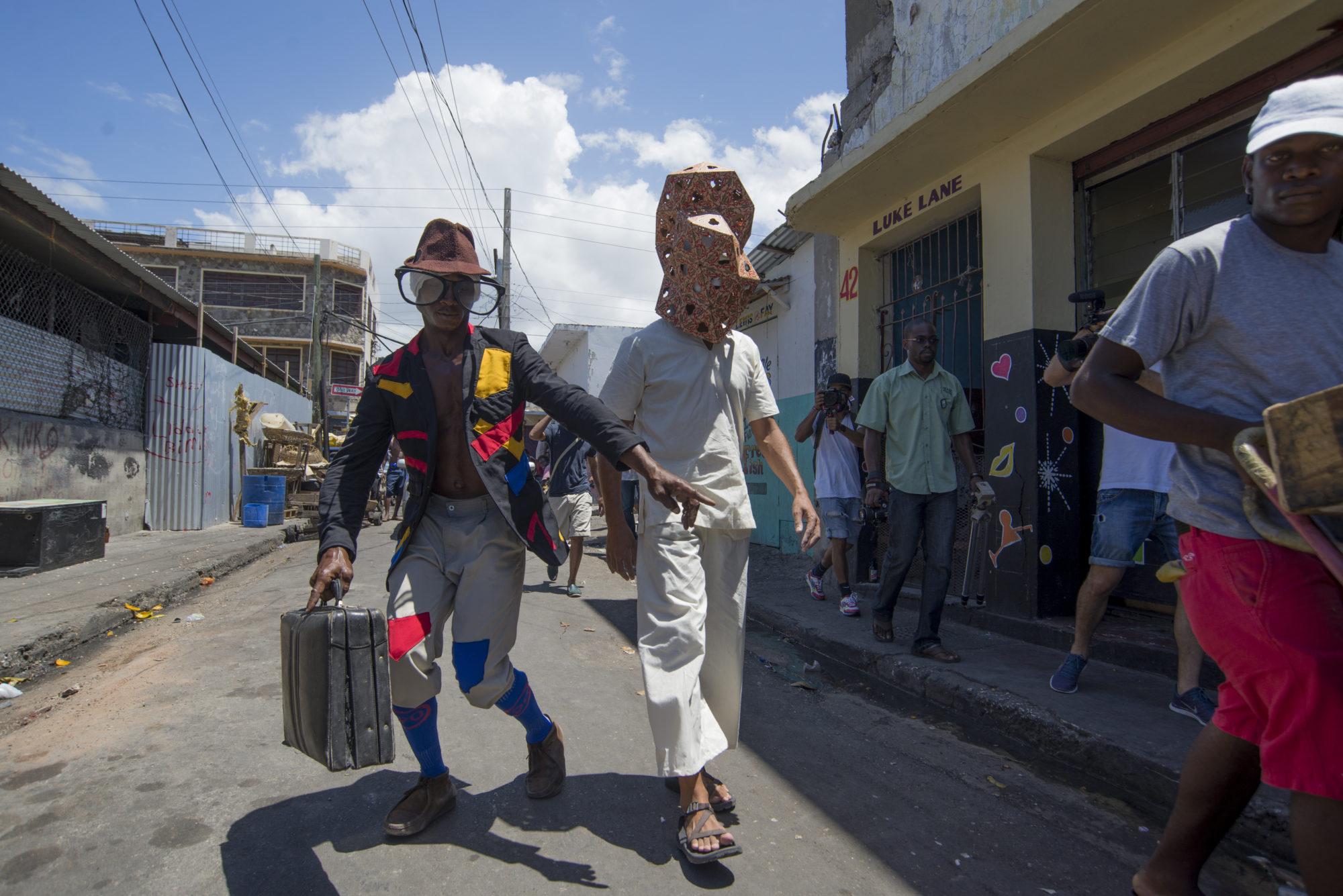 Two men walk down a street wearing props