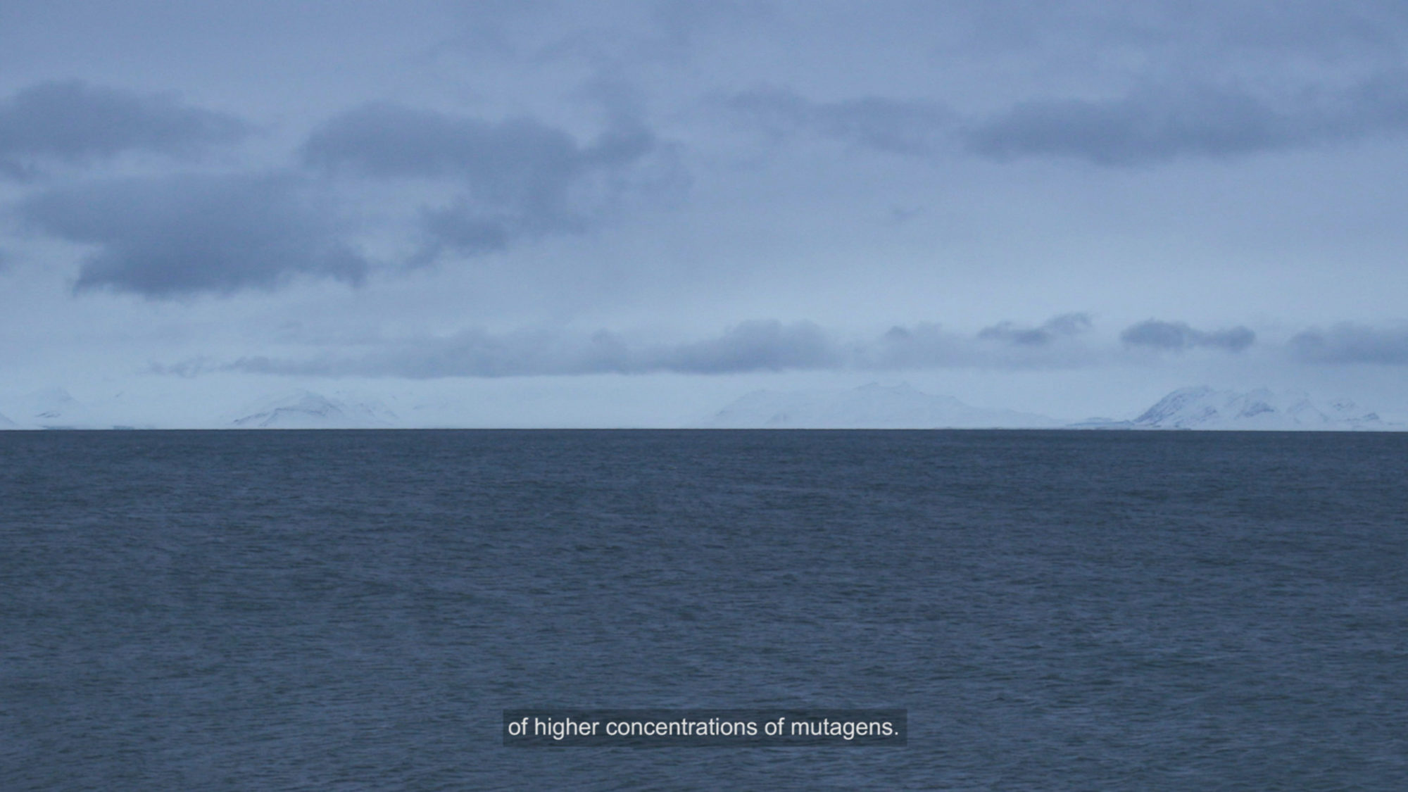 video still of large ocean with dull blue skies