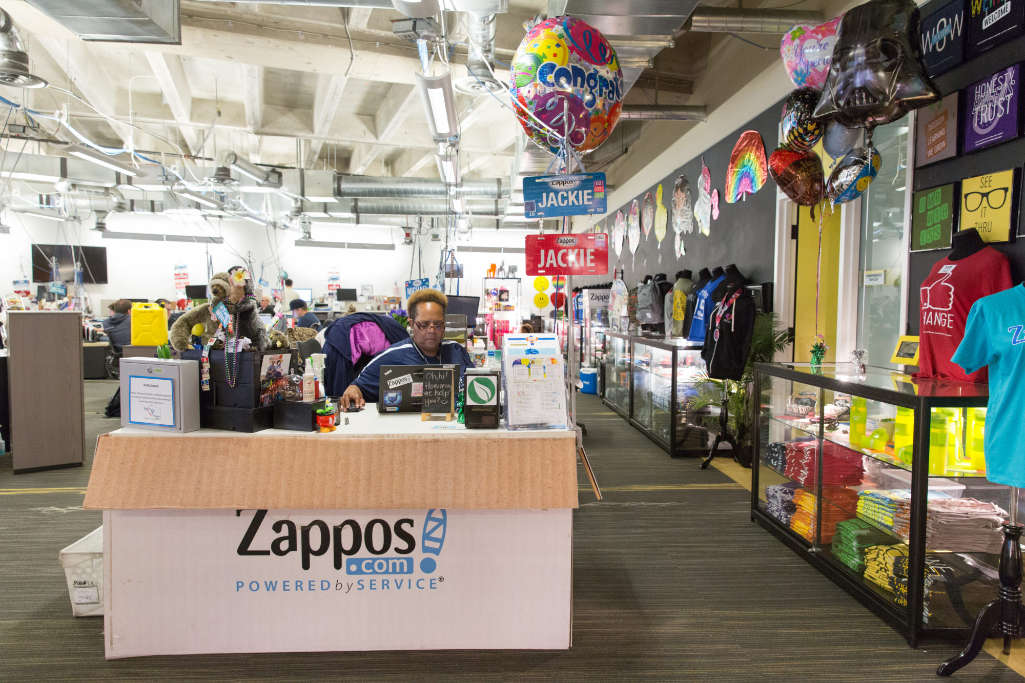 storefront with tshirts, balloons and desk resembling cardboard box