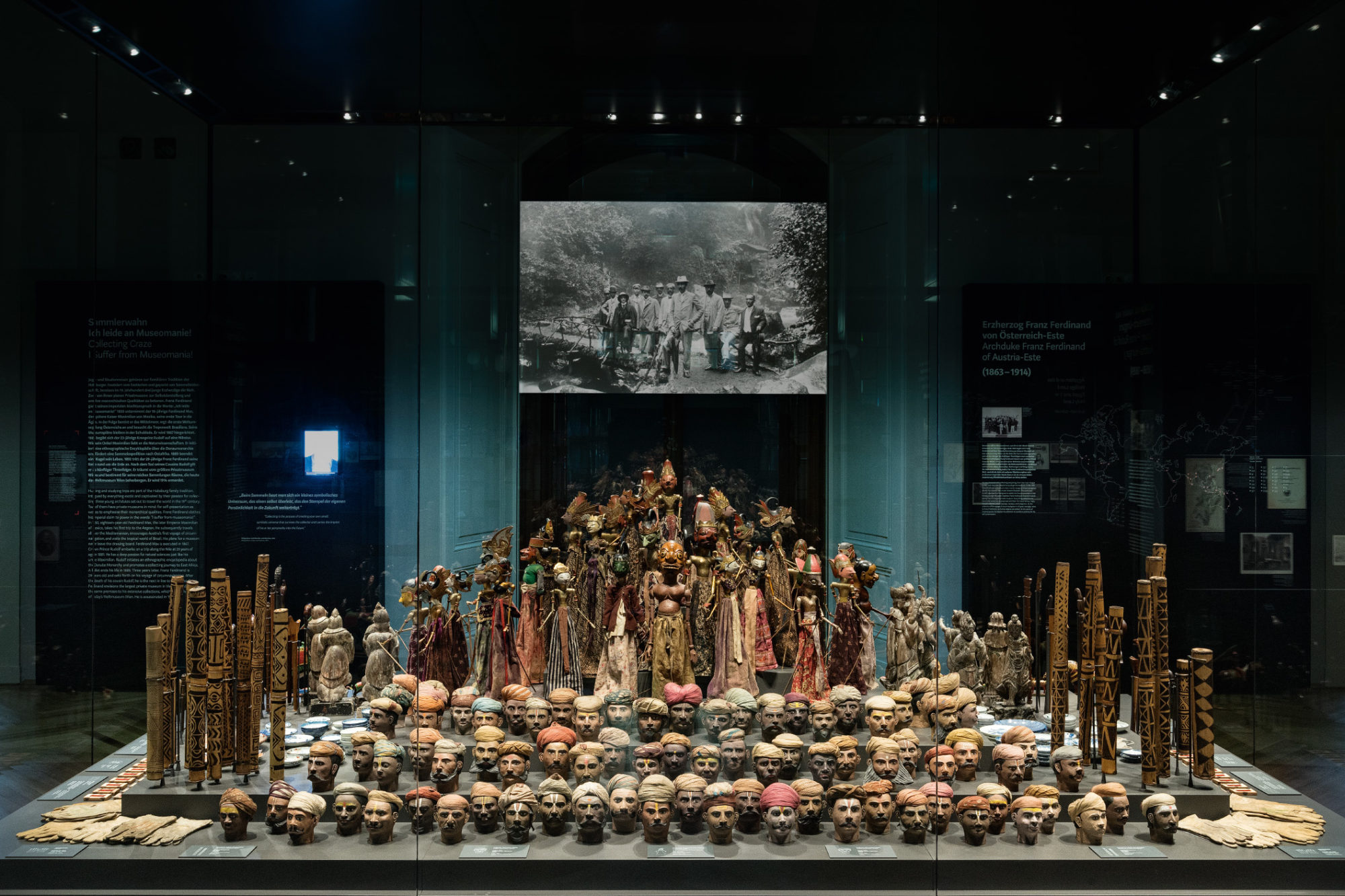 An installation of figurines and rows of heads in a museum