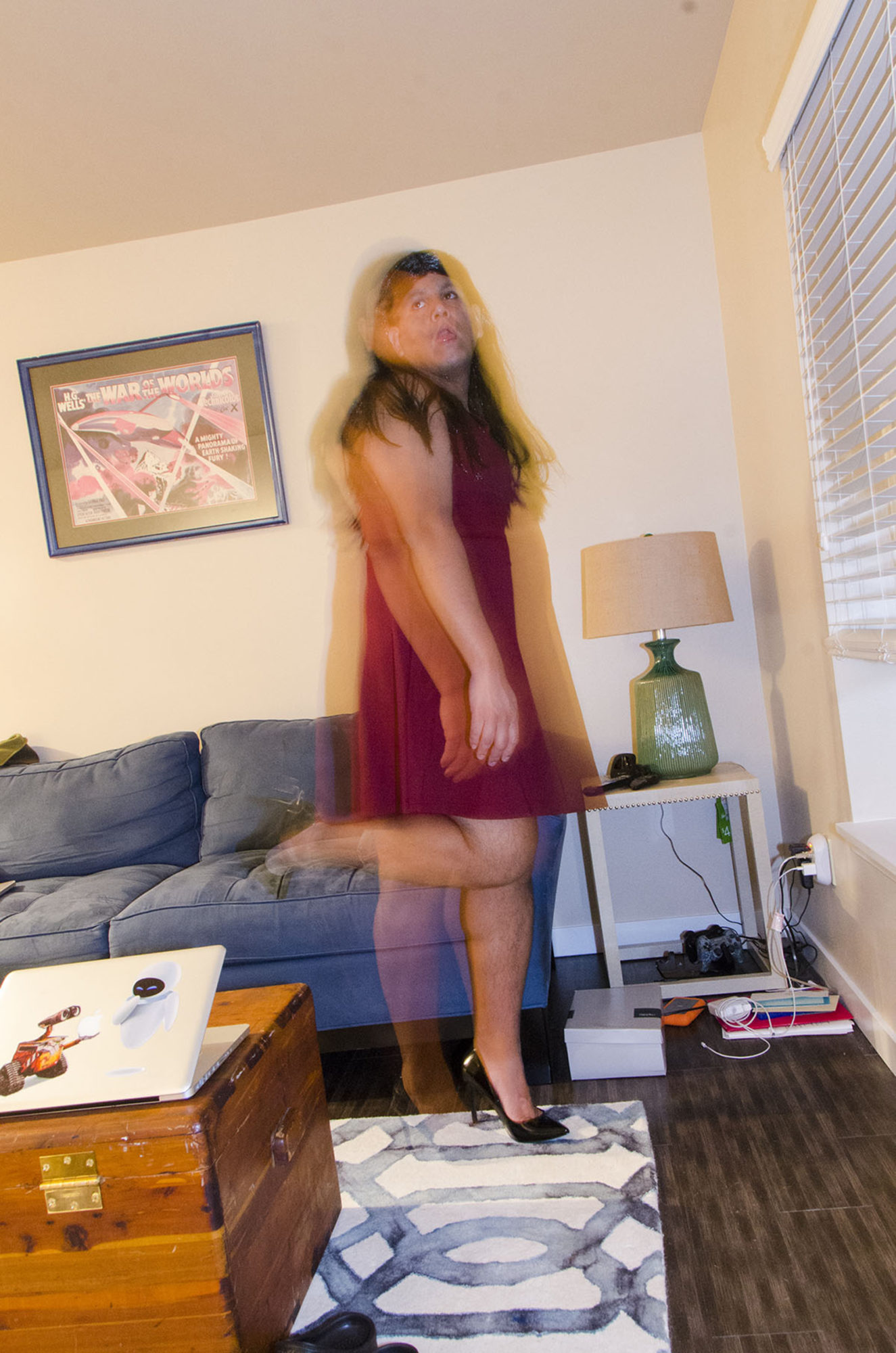 a blurred person in a dress poses in a living room