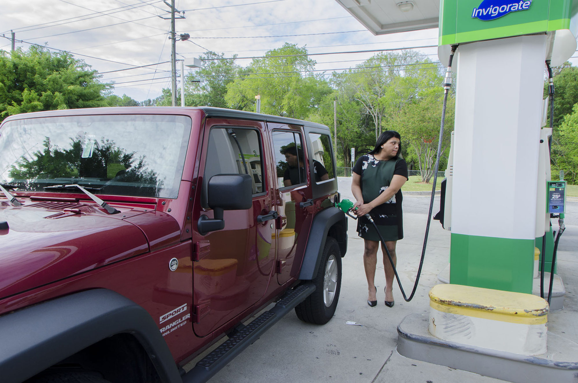 A woman pumps gas at a gas station